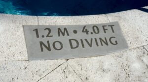 Inset depth minders in solid surfacing are easier on bare feet than brass lettering.